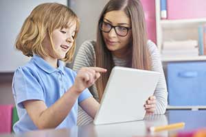 Child playing an online educational game on tablet